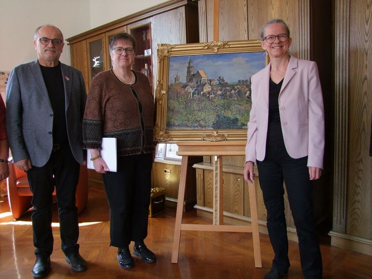 Sie freuen sich, dass das Gemälde »Blick auf Kamenz mit St. Marien und dem Roten Turm« von Otto Garten nun wieder im Kamenzer Rathaus zu sehen ist: Oberbürgermeister Roland Dantz, Christina Tonnecker, Verein der Freunde und Förderer der Städtischen Sammlungen, und Sylke Kaufmann, Leiterin der Städtischen Sammlungen (v.l.n.r.).