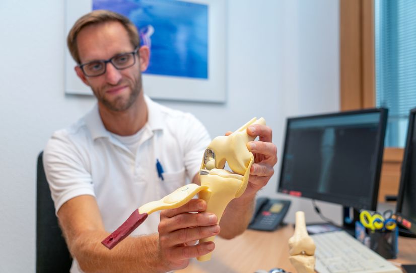 Tobias Bode, Facharzt Orthopädie &amp; Unfallchirurgie, zeigt eine Knieprothese.