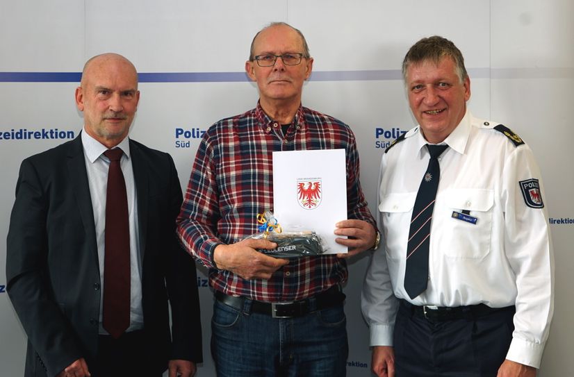 Karl-Heinz Simson erhält eine Auszeichnung für 20 Jahre Tätigkeit von Michael Scharf, Leiter Referat 45 beim Innenministerium (links), und Direktionsleiter Sven Bogacz (rechts).