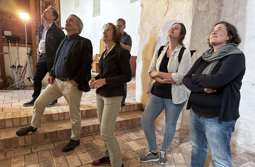 Eine Gruppe Sachverständiger begutachtet die Wandmalereien in der Kirche in Riedebeck. Mit dabei ist Landeskonservator Thomas Drachenberg (2.v.l.).