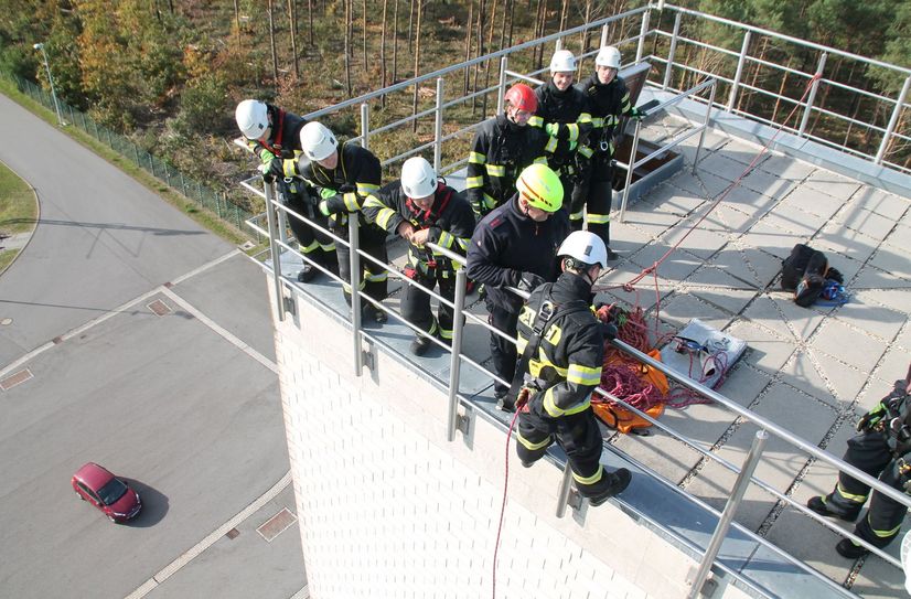 Einer der Praxis-Inhalte ist die Simulation eines Feuers in einem speziellen Brandhaus oder das Abseilen vom sogenannten Steigerturm. Ausbilder Christian Knöbel will wissen, ob wir uns das Abseilen vom Turm anschauen möchten. Und nur ein paar Minuten später stehen wir im Korb der Drehleiter - in schwindelerregender Höhe. Was es für Überwindung kosten mag, allein um über die Brüstung zu klettern.