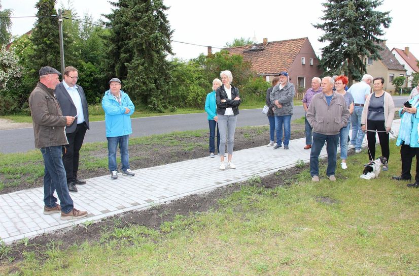 Eröffnen den neuen Gehweg gemeinsam mit Einwohnern von Göbitz (vo.li.na.re.): Ortsvorsteher Eckhard Nadebohr, Amtsdirektor Marten Frontzek und Bürgermeister Lutz Modrow.