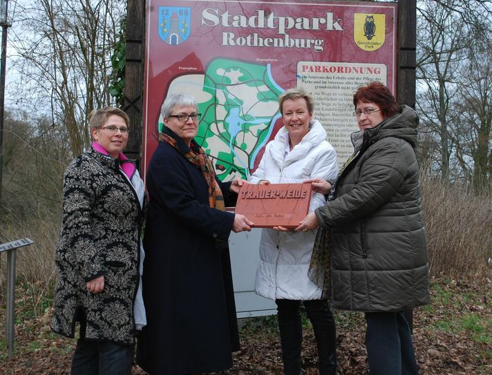 V.l.n.r.: Katrin Weinert vom Martinshof, Petra-Edith Pietz, Heike Böhm und Rita Friedland von der Stadtverwaltung zeigen eine der Keramikplatten, die entlang des Baumlehrpfades die verschiedenen Bäume beschreiben. Foto: Keil
