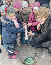 Die Kinder versenken mit SEEG-Chefin Birgit Richter die Zeitkapsel im Fundament der neuen Kita am Leitmeritzer Bogen.