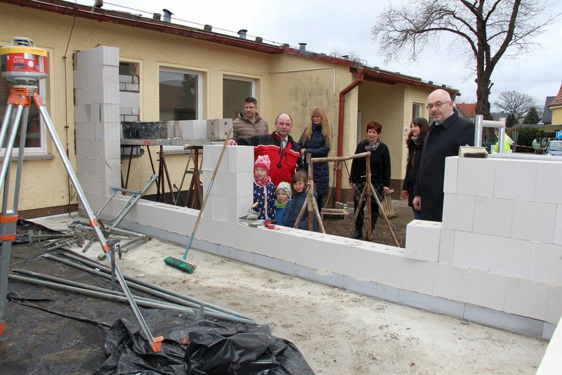 Mit den drei Kita-Kindern Annelie, Eddie und Selma schaut sich Bürgermeister Reiner Krämer (2.vo.li.) mit André Maywald (re., Vorstand Diakonie Libera), Kita-Leiterin Annett Uhlig (3.vo.re.) und Elternrats-Vorsitzende Julia Hönisch (2.vo.re.) den Fortschritt des künftigen Forscherlabors an. Mit dabei sind auch Planer Alexander Kraus (li.) aus Cottbus und Franziska Kotte-Bauer aus dem Bauamt des Amtes Ortrand. Foto: sts