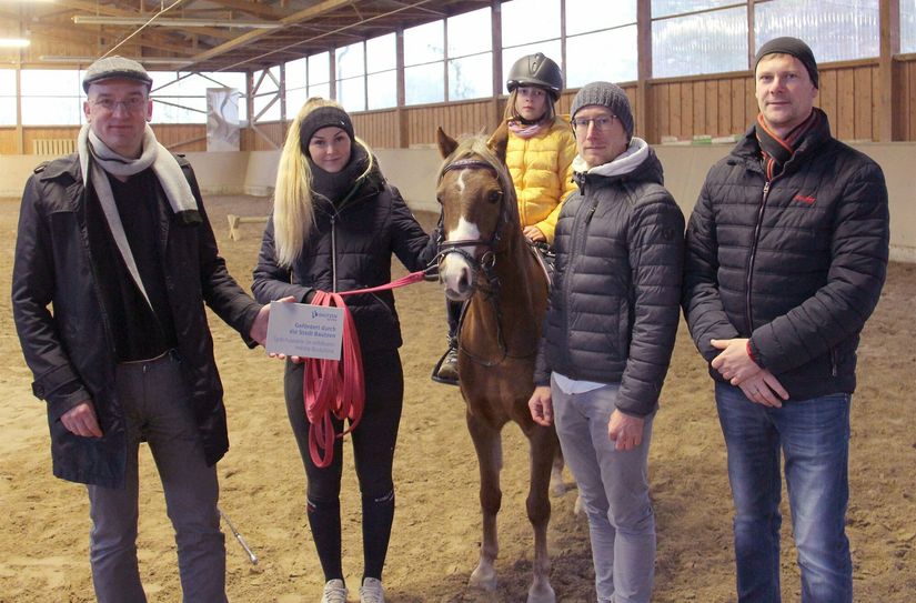 Philipp Sämann, Falk Krämer, Cathalea auf Barbie, Reitlehrerin Lea Seehuber und Bürgermeister Dr. Robert Böhmer (v.l.) freuen sich über das reparierte Dach der Reitsporthalle.