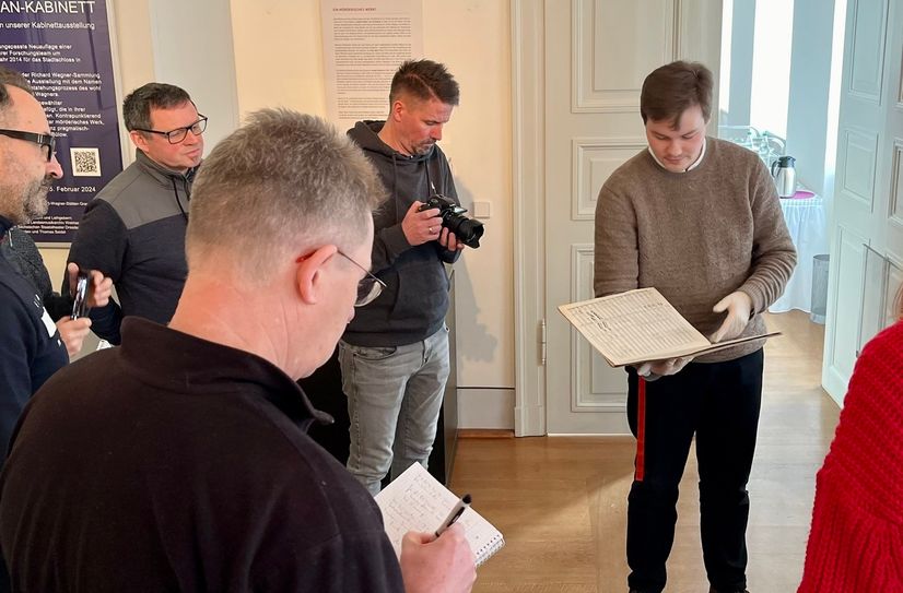 Tom Adler zeigt die originale Partitur zu "Tristan und Isolde" der anwesenden Presse.