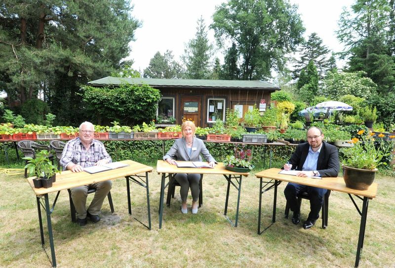 Dahme-Spreewalds Vize-Landrätin Susanne Rieckhof (M.) unterzeichnet zusammen mit Geschäftsführer Wolfgang Krüger (l.) und Bürgermeister Björn Langner die neue Kooperationsvereinbarung im Biogarten Prieros. Foto: Gerlinde Irmscher/LDS