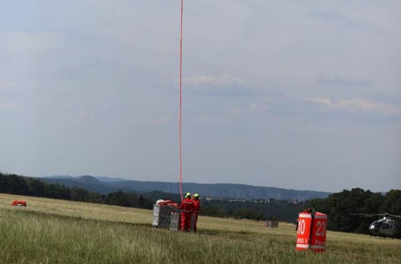 Um solche Lasten sicher zu transportieren brauchen Piloten auch Flughelfer am Boden.