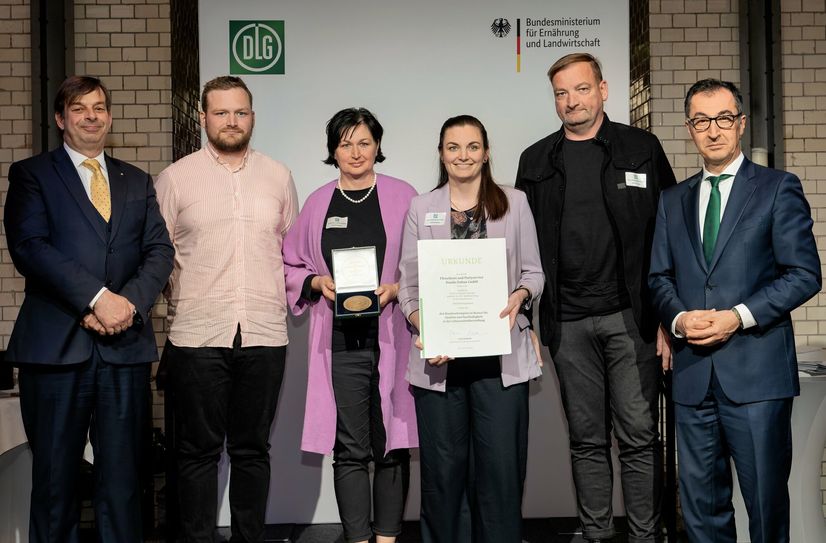 Bundesminister Cem Özdemir (r.) überreichte Urkunde und Medaille gemeinsam mit DLG-Präsident Hubertus Paetow (l.) an Danilo, Ludwig, Annett und Sophie Dubau.