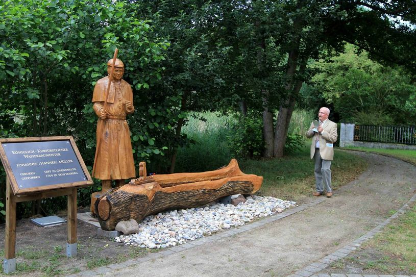 Dr. Siegfried Thomas, Vorsitzender des Heimatvereins Grünewalde, würdigt die Leistungen des Wasserbaumeisters, dessen Denkmal jetzt am Dorfteich in Grünewalde steht. Foto: Mirko Sattler