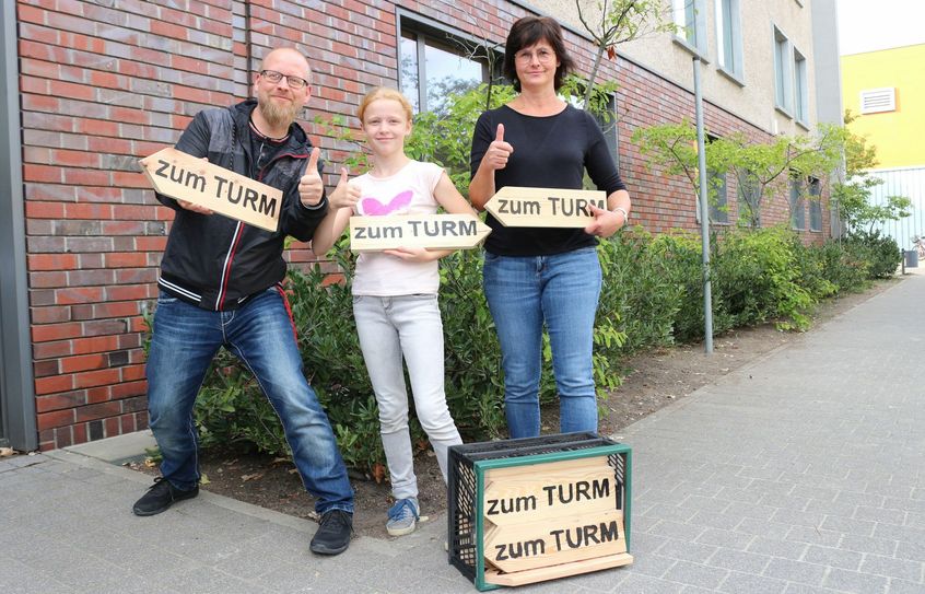 25 beschriebene Wegweiser überreichten Hortleiterin Kerstin Pietzig (rechts) und Schülerin Helena an Jan Hornhauer, den Pressesprecher der Stadt Calau. Jetzt werden sie durch Mitarbeiter des Bauhofes montiert und weisen den Weg in Richtung Aussichtsturm »Calauer Schweiz«. Foto: Stadt Calau/Rieke Faatz