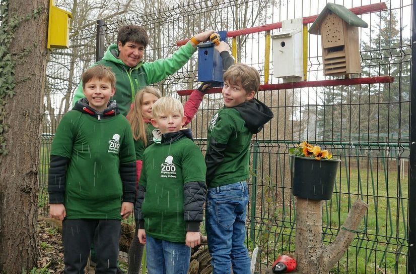 Zooschulpädagogin Silke Kühn mit den Zoo-Kids beim Anbringen eines Nistkastens.