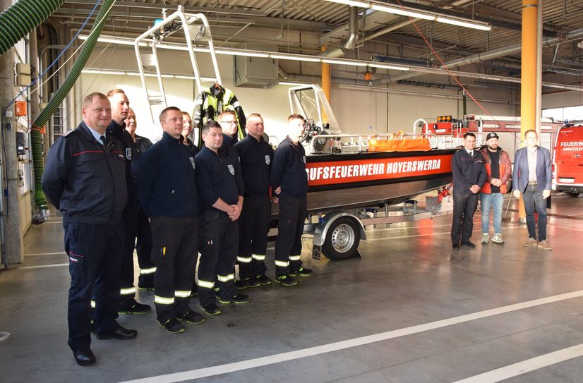 Mitglieder der Feuerwehr stellen mit Fachbereichsleiter Feuerwehr Benny Bastisch, Stadtrat Nick Jantschke und Bürgermeister Mirko Pink das neue Rettungsboot in Dienst.