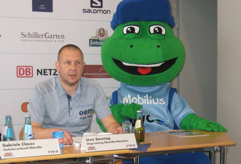 Organisator Uwe Sonntag freut sich über die „moralische Unterstützung“ durch das VVO-Maskottchen bei der Vorbereitung des 19. Oberelbe-Marathons. Foto: Eberlein