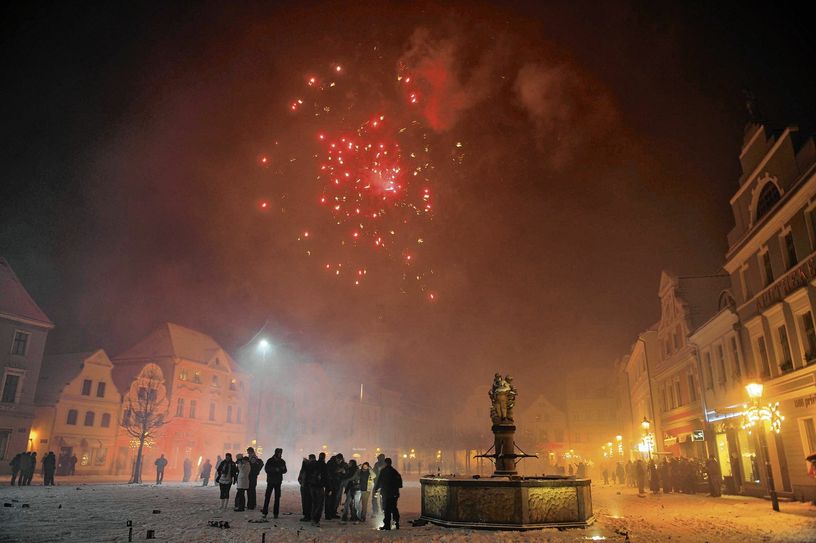 Menschen zünden Raketen auf dem Cottbuser Altmarkt. Im Jahr 2019 war das auch noch erlaubt. Aber ein lautes und leuchtend buntes Feuerwerk wird in diesem Jahr wohl wieder nicht am Nachthimmel zu sehen sein. Foto: Michael Helbig