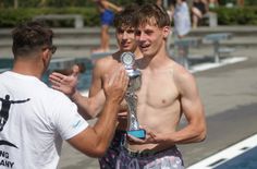 Fabian Bartzsch nimmt den Siegerpokal im Arschbomben-Wettbewerb entgegen.