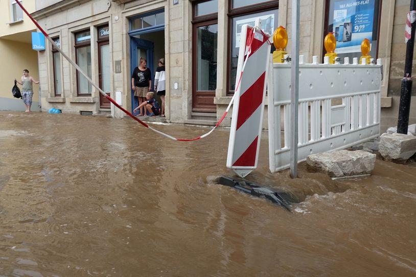 Die geplatzte Trinkwasserhauptleitung setzt Fußweg, Fahrbahn und Keller unter Wasser.