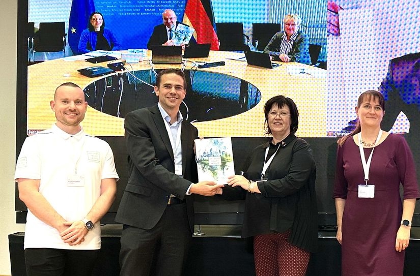 Lars Katzmarek (Pro Lausitz e.V.), Markus Niggemann (Stadt Cottbus), Christine Herntier (Lausitzrunde) und Antje Klose (Landkreis Görlitz) übergaben die Bewerbung zum Net Zero Valley Lausitz an das Bundesministerium  für Wirtschaft und Klimaschutz (BMWK), vertreten durch Bernhard Kluttig, Abteilungsleiter Industriepolitik, der virtuell zugeschalten war (auf dem Screen Mitte).