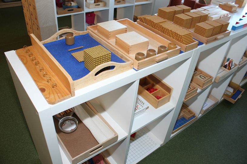 Die Räume sind in verschiedene Bereiche geteilt, an denen die Materialen zum jeweiligen Thema bereitliegen. Hier im Bild der Bereich Mathematik. Womit sich beschäftigt wird, entscheiden die Kinder selbst.