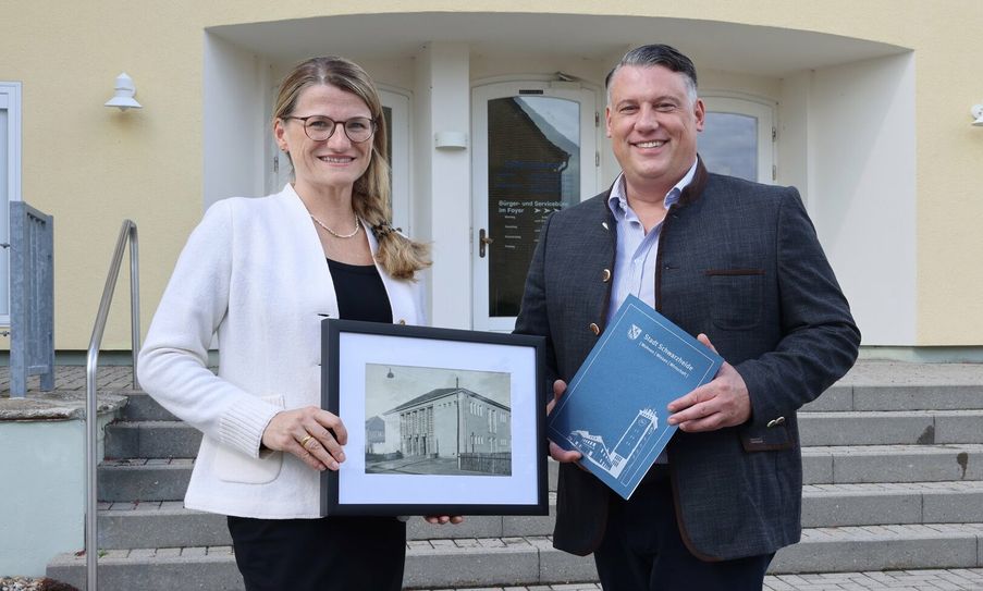 Anne Francken, kaufmännische Geschäftsführerin der BASF Schwarzheide GmbH übergibt das Bilderarchiv an Schwarzheides Bürgermeister Christoph Schmidt.
