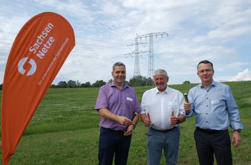 Carsten Protze von SachsenNetze (mit Probestück alter Stromleitung), Neustadts Bürgermeister Peter Mühle und Dr. Steffen Heine, GF SachsenNetze (mit Probestück neuer Stromleitung) (v.l.) vor fertigem Teilstück bei Dürrröhrsdorf-Dittersbach.