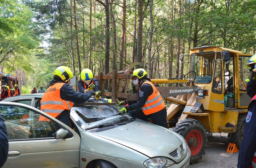 Die Gabel des Radladers hat sich in dem Renault verkeilt. Der Fahrer sitzt noch verletzt und einklemmt im Auto und muss von der Feuerwehr befreit werden.