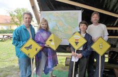 Die gelben Schilder mit den Piktogrammen kennzeichnen die entsprechenden Hörstationen in der Landschaft, die alle mit dem Fahrrad zu erreichen sind. Die Theater- und Landschaftsprotagonisten Stefan Nolte, Bernadette La Hengst, Ruth Feindel und Hendrik Scheel (v.l.n.r.) stehen mit den Piktogrammen vor der Standortkarte, die auch unter www.recherchepraxis.de zu sehen ist.