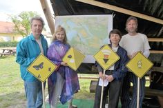 Die gelben Schilder mit den Piktogrammen kennzeichnen die entsprechenden Hörstationen in der Landschaft, die alle mit dem Fahrrad zu erreichen sind. Die  Theater- und Landschaftsprotagonisten Stefan Nolte, Bernadette La Hengst, Ruth Feindel und Hendrik Scheel (v.l.n.r.) stehen mit den Piktogrammen vor der Standortkarte, die auch unter www.recherchepraxis.de zu sehen ist.