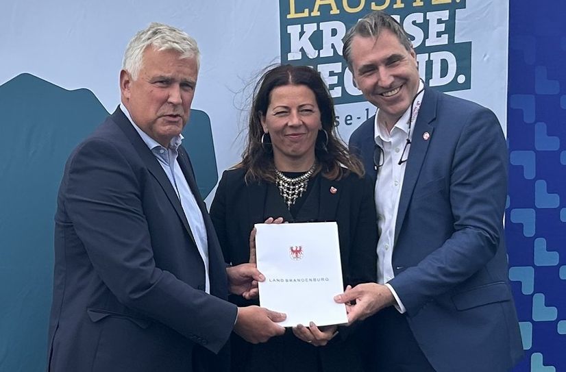 Der Lausitzbeauftragte Dr. Klaus Freytag überreicht den Zuwendungsbescheid an Stadtentwicklungsdezernentin Doreen Mohaupt und EGC-Geschäftsführer Tim Berndt.