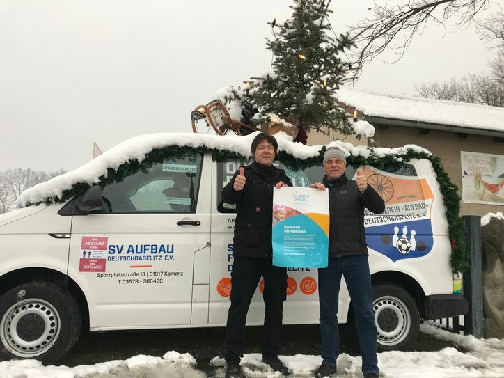Jürgen Demski vom Sonnenstrahl e.V. (l.) und SV Aufbau-Präsident Norbert Adler vor dem festlich geschmückten Vereinsbus. Foto: pm