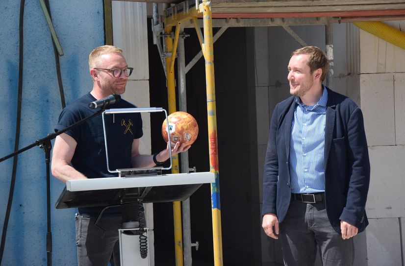 Dr. Stephan Ohm übergibt dem RAA-Geschäftsführer Jens Leschner einen Fußball, der die Venus darstellen soll.