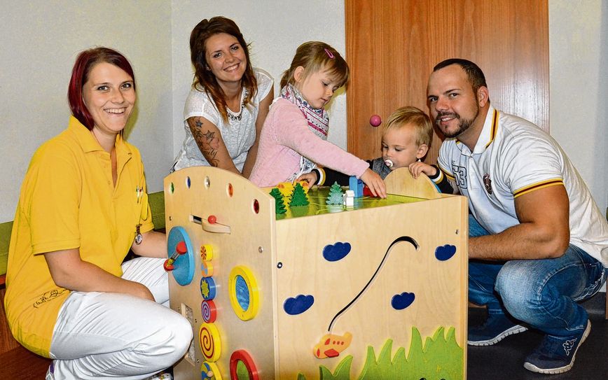 Lydia Klunker (li.) präsentiert den neuen Motorik-Würfel für die Kinderklinik. Katja und Thomas Langer freuen sich, dass die Spende so gut angekommen ist und nun die Materialien dafür gekauft wurden. Dominik und Emily testen das Spielzeug bei ihrem Besuch auf der Kinderstation in Lauchhammer. Foto: Klinikum Niederlausitz/ Daniela Graß