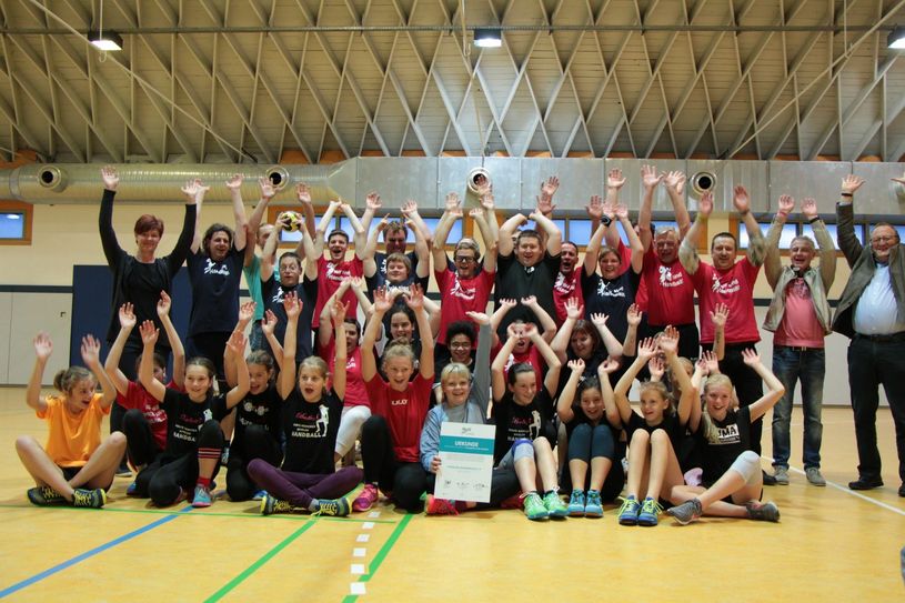 Ein Grund zum Jubeln haben sie alle. Das Special Olympic Team (SOT) und die Handball-Mädels der D-Jugend zeigen stolz die Urkunde vom Freistaat Sachsen. Mit dabei steht rechts außen Bürgermeister Winfried Lehmann (CDU), von dem die Initiative zur Nominierung ausging.                                                                                                              Foto: Lindackers