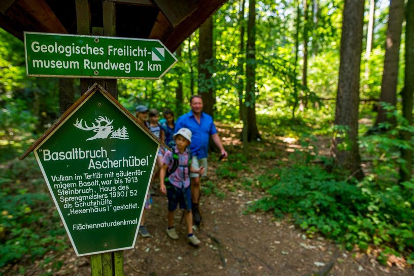 Wanderer auf dem Geologischen Lehrpfad. Hier am Ascherhübel bildeten sich vor zehn Millionen Jahren die Basalte. Zeitweise wurde der Basalt  des Ascherhübels zum Straßenbau verwendet, erwies sich aber als unbrauchbar dafür. Foto: PR