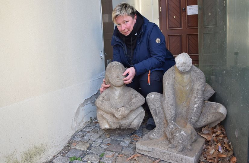 Kerstin Noack zeigt die beschädigte Kunststeinskulptur »Kinder mit Schildkröte«. Für die Restaurierung spendeten die diesjährigen Projektteilnehmer.
