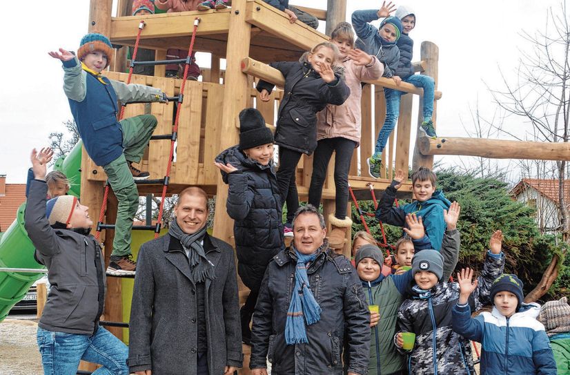 Mirko Knöfel, der Bürgermeister von Klipphausen (l.) und Lutz Müller, der Leiter der Grundschule Naustadt mit den Kindern auf dem neuen Spielplatz.