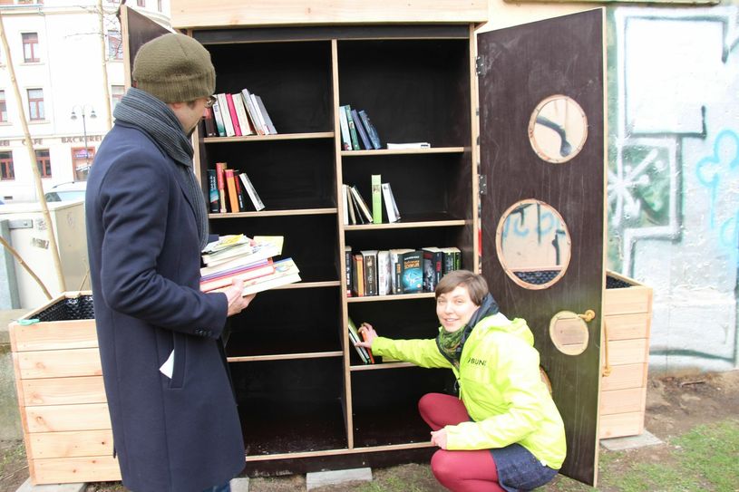 Dr. David Greve (Landesgeschäftsführer BUND Sachsen) und Projektkoordinatorin Sarah Morwinski befüllen den neuen Büchertauschschrank am Konkordienplatz.