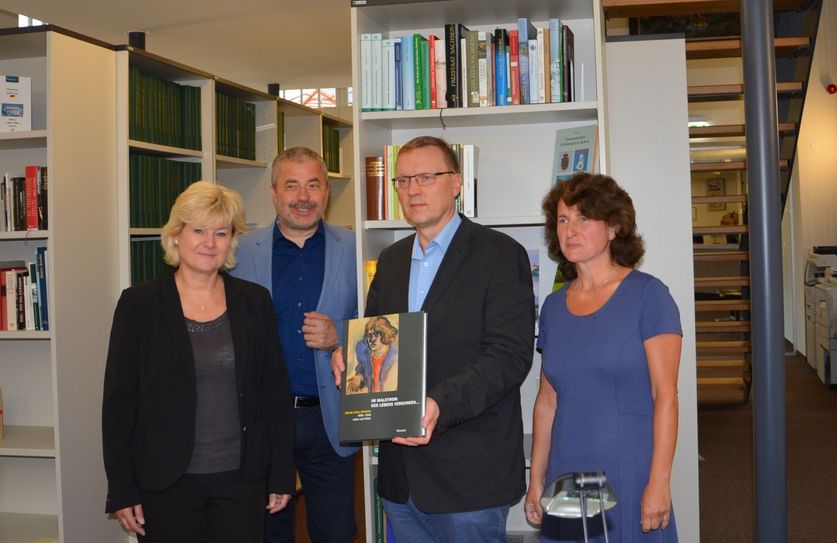 Dr. Boris Böhm (2. v. re.) und Landrat Michael Geisler (2. v. li.) übergaben an die  Leiterin der Stadtbibliothek, Gaby Langmann (li.) und Anett Kunze vom Archivverbund  (re.) eine Auswahl an Büchern zu Elfriede Lohse-Wächtler. Foto: Wo