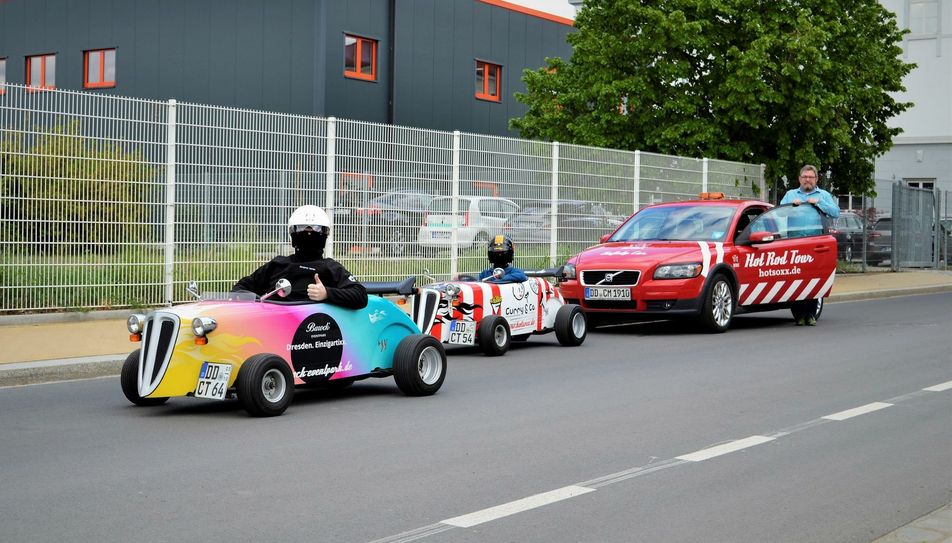 HOTSOXX-Inhaber Torsten Meisel mit zwei seiner Mini-Hot-Rods und der aktuellen Einweg-Gesichtsbedeckung der Fahrer. Foto: PR