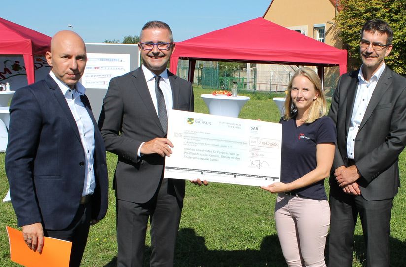 Kultus-Amtschef Wilfried Kühner (2.v.l.) überreicht im Beisein des 1. Beigeordneten des Landkreises Bautzen, Jörg Szewczyk (r.) und des AWO-Geschäftsführers Marcus Beier (l.) den Fördermittelbescheid an die Einrichtungsleiterin Katja Förster.