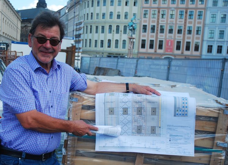Amtsleiter Prof. Koettnitz zeigt am Plan, wie die Steine auf den Tuchbahnen verlegt werden.