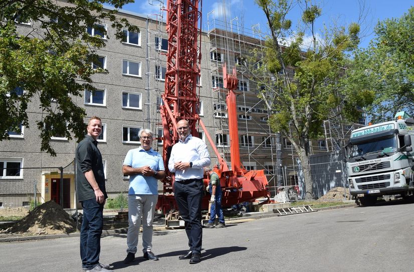 Matthias Zindler, Axel Fietzek und der Niederlassungsleiter Dresden der Firma Wolff und Müller, Matthias Seifert, stehen vor dem Haus, das sie zusammen umbauen.