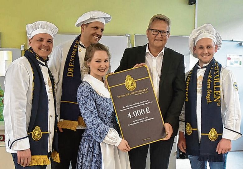 Stollenmädchen Lina Trepte und Dresdner Stollenbäcker übergaben kürzlich an den Schulleiter der Förderschule, Jörg Jacobi, den Erlös. Foto: Mike Schiller