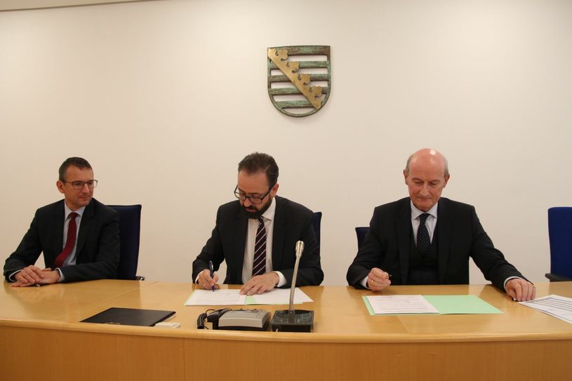 Justizminister Sebastian Gemkow (Mitte) und der Präsident der Rechtsanwaltskammer Dr. Detlef Haselbach (re.) unterzeichnen im Beisein von Andreas Beeskow (Amtsgerichtsdirektor in Pirna) die Vereinbarung über die Eröffnung der anwaltlichen Beratungsstelle in Pirna.                                                                                                           Foto: Schramm