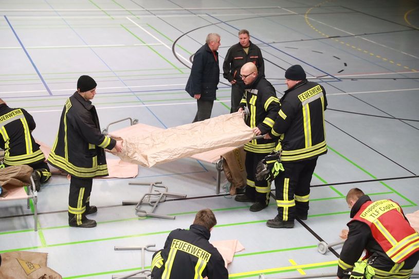 Aufbau der Feldbetten durch die Feuerwehr in der Sporthalle Pirna Sonnenstein. Foto: Marko Förster