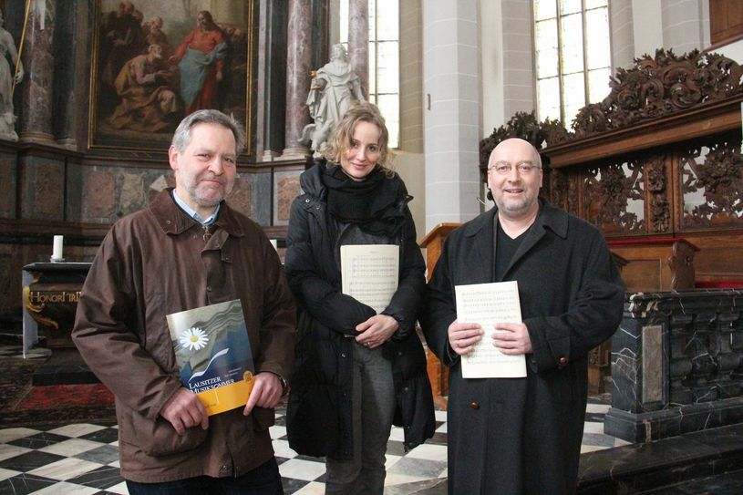 Götz Müller vom Kulturbüro der Stadt Bautzen, Gesangs­pädagogin Stephanie Hauptfleisch und Kirchenmusikdirektor Friedemann Böhme (v.l.n.r.) vorm Hochaltar des Doms St. Petri – dem Auftrittsort des Projektchores zum Lausitzer Musiksommer.   Foto: Stadtverwaltung
