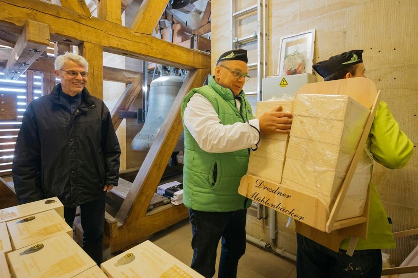 Bäckermeister Rüdiger Zopp (mi.) beim Einlagern der Christstollen in den Glockenstuben der Frauenkirche, links im Bild Pfarrer Markus Engelhardt.