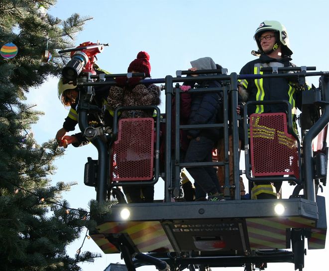 Mit Hilfe der Kameraden der Feuerwehr und ihrer Drehleiter wurde der Weihnachtsbaum der Kinder in Elsterwerda geschmückt.
