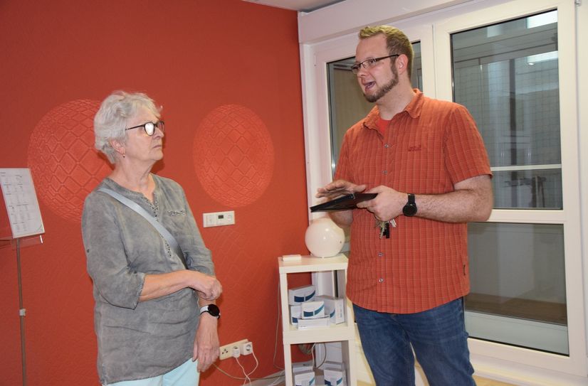Ben Bartuschka erklärt Petra Dommenz, wie sie ihre Wohnung mit smarter Technologie ausstatten  kann.